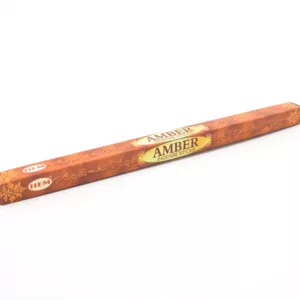 Relaxing amber incense stick with gold label, surrounded by billowing smoke on white background.