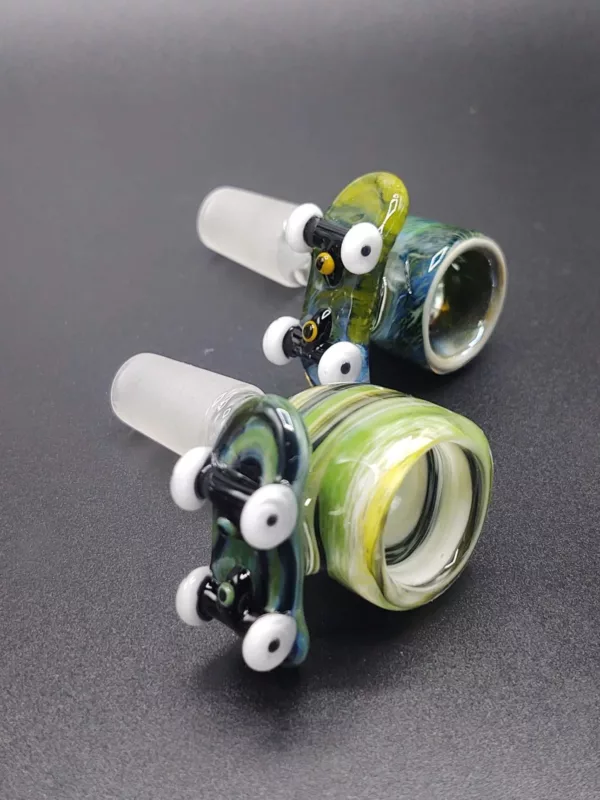 Handmade glass pipes with green and blue accents, featuring round bowls and small holes. Perfect for smoking enthusiasts.