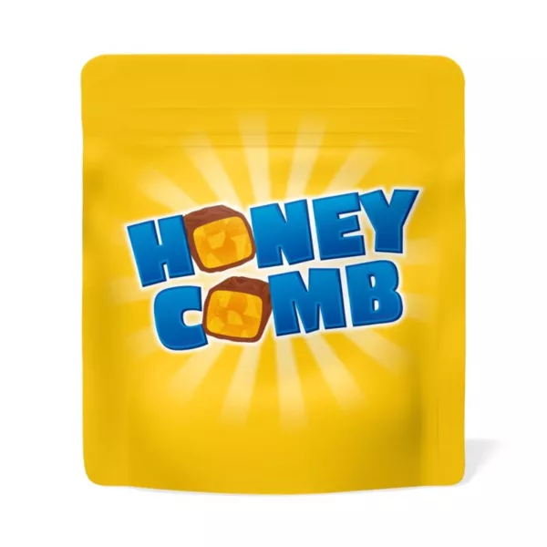 Honeycomb candy with yellow Honeycomb text, bright white background, and a sun shining down. Irregular shape with yellow, brown, and yellow specks.