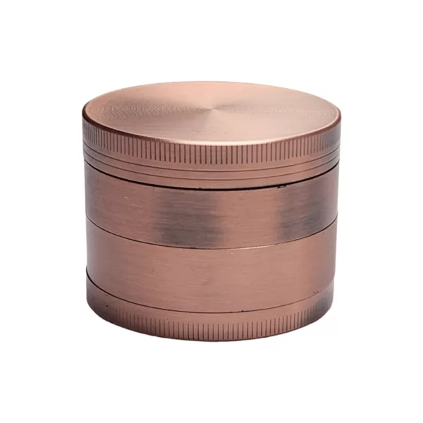 Copper-colored grinder with circular shape, multiple layers of metal, polished surface, matte finish, small opening for smoking material.