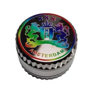 Metallic object with colorful crown and lion design on a rainbow background, likely a grinder or small container for smoking.