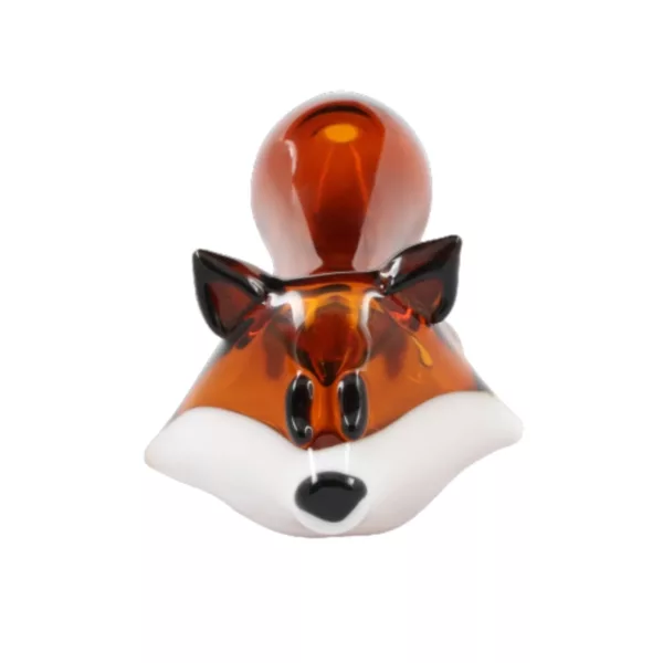 This image displays a Foxy Glass Pipe by Chameleon Glass, featuring a glass figurine of a fox with black and brown fur and white eyes, sitting on a white background.