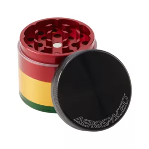 Colorful 4-piece grinder with yellow, red, and green design. Made of metal with an anodized finish. Two large airflow holes and small handle. Suitable for grinding herbs or other materials.