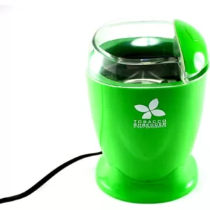 Green electric shredder with clear cover, large plastic blade, and motor. Sitting on white surface with cords attached.