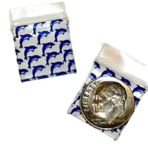 Small blue and white fabric bag with a dolphin coin inside, listed on a smoking company website.
