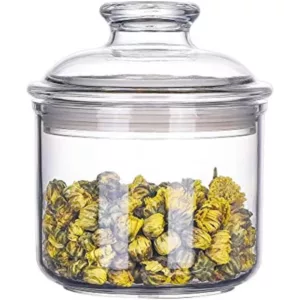 Glass jar with wooden handle and screw-on lid, filled with yellow flowers and green leaves. Perfect for preserving and displaying botanicals.