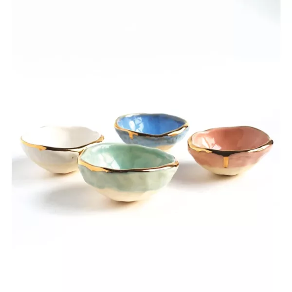 Set of four small ceramic bowls with gold rim and different colors (blue, green, pink, yellow) on white surface.
