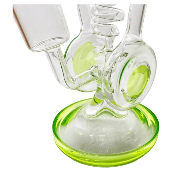 Glass bong with green base and clear stem. Stem has small hole at top, base has small hole at bottom. Bong sits on clear round base.