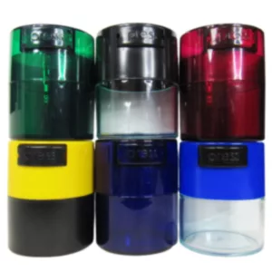 Five small, round containers of different colors (red, green, blue, yellow, black) for storing small objects such as herbs. Transparent plastic body with metal or plastic lid. Red container on top.