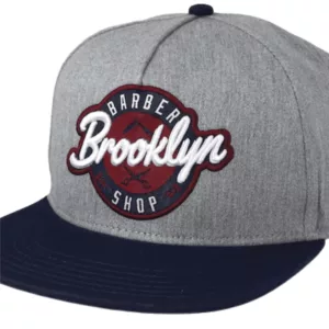 Cotton snapback hat with Brooklyn Barber logo on front, available in gray and navy blue. Adjustable closure.