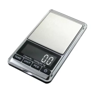 Chrome-1500 LED digital scale displays weight in grams or ounces with large LCD digits and a gram/ounce switch. It sits on a white surface.