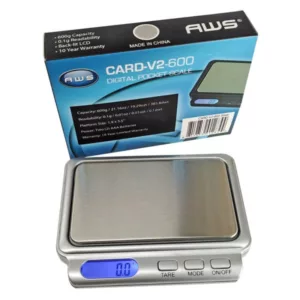 Compact electronic scale (Card-V2-600-AWS) with digital display for weighing small objects in grams and kilograms. Suitable for laboratory use.
