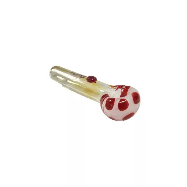 Red and white polka dot glass pipe with small hole at end, made of clear glass and sitting on white surface.