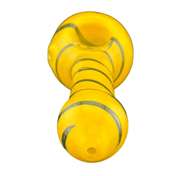Small glass bong with yellow and white stripe design, sitting on white surface with shadows.