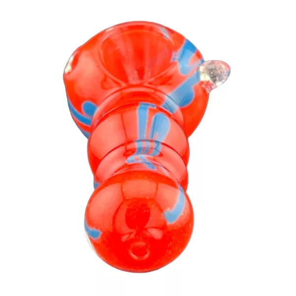 Red and blue glass pipe with clear base and blue and red swirl pattern. Small, round base and slightly tapered shape. Smooth, glossy surface. Sits on white background.
