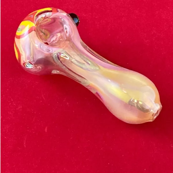 Handcrafted glass pipe with floral swirl design, yellow stem, red accents, and pink bowl.