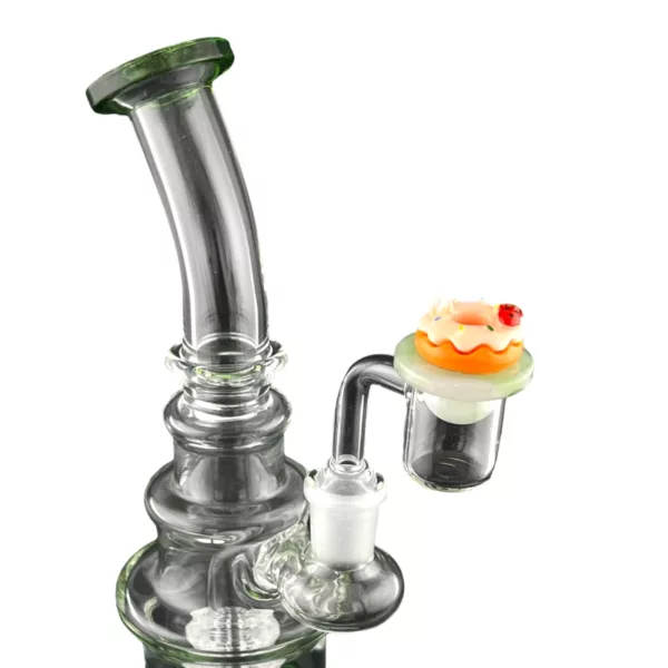 A glass bong with a small orange cake-shaped carb cap on top, sitting on a white background.