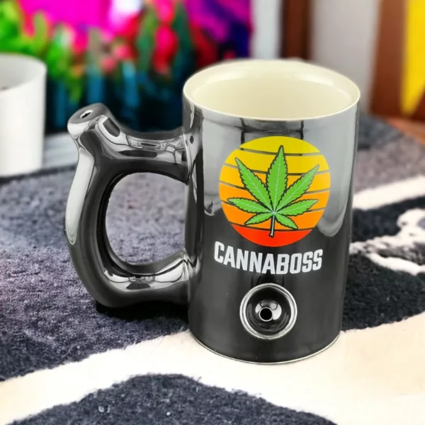 A ceramic mug with a stainless steel handle and marijuana leaf design, available on a smoking company website.