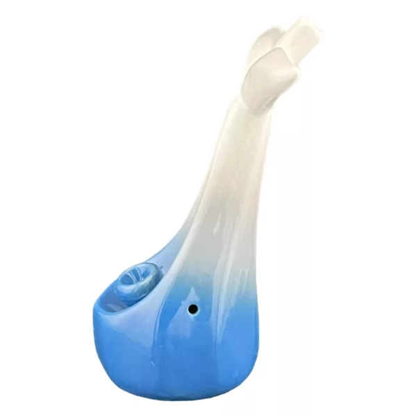 Dolphin-shaped pipe with blue and white glaze, long curved neck and tail, smooth body, small hole for smoke, and rounded base with small ring.