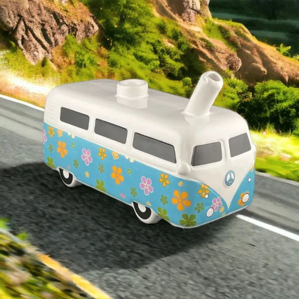 Vintage bus transformed into a colorful novelty pipe, driving down a winding road with hills and trees in the background.