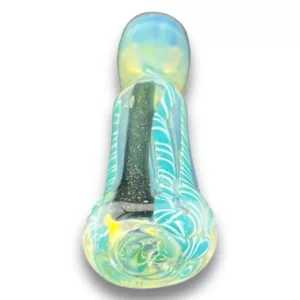 Glass pipe with blue and green swirled design, clear glass stem, and small hole for smoking. Base has hole for herb and sits on white surface.