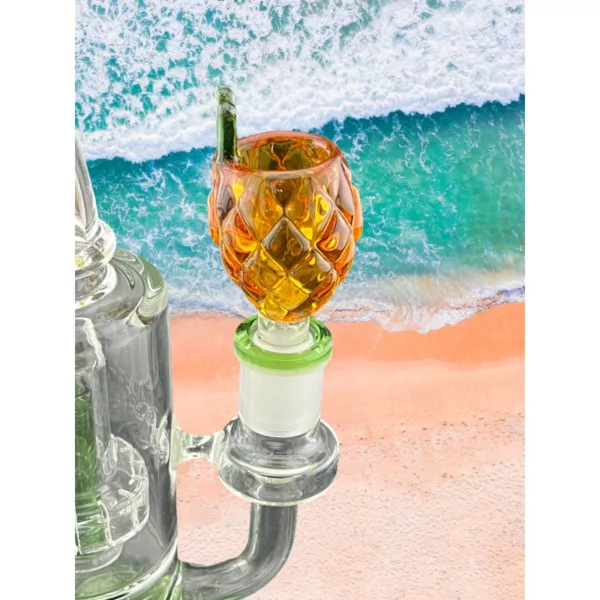Glass bowl filled with green drink on beach with ocean view. Clear sky, sunset, green, blue, orange colors.