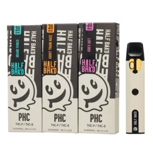 PHC Disposable 3g - Half Bak'd e-cigarette cartridges are white with black accents, have a screw-on cap and clear plastic base, and come in a white and black labeled packaging with a baked cookie illustration.