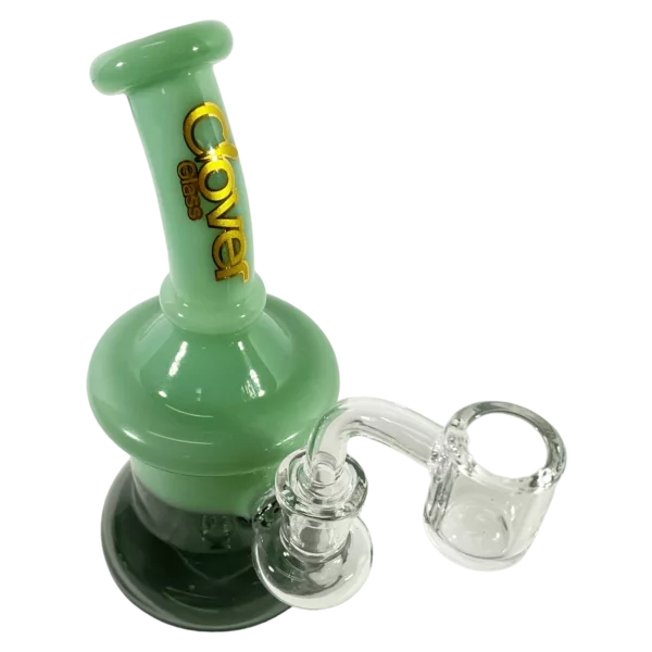 A clear glass bong with a green base and a small, round bowl featuring a circular percolator. The stem is also clear and attached to the base.