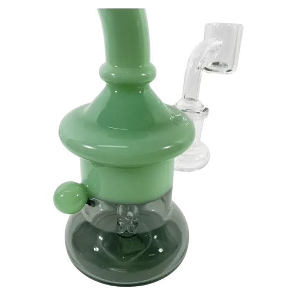 A clear glass water pipe with a white base and green spigot, featuring a black tip and attached to the body of the pipe.