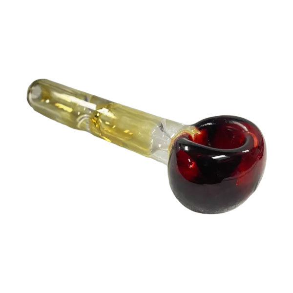 Handcrafted hourglass-shaped spoon with yellow handle, black ring, deep red bowl & small crack in handle. Green background.