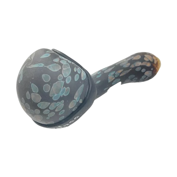 Glass pipe with black and white pattern, silver ring with blue dot and white dots on sides, curved mouthpiece, pointed end, green background.