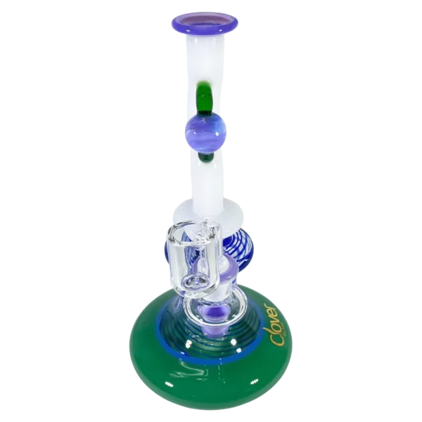 Glass bong with blue and green base and clear stem, sitting on small round base with green and blue pattern and center hole.