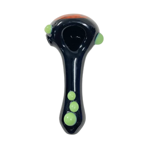Black glass pipe with green and yellow beads arranged in a smiley face pattern on green background.