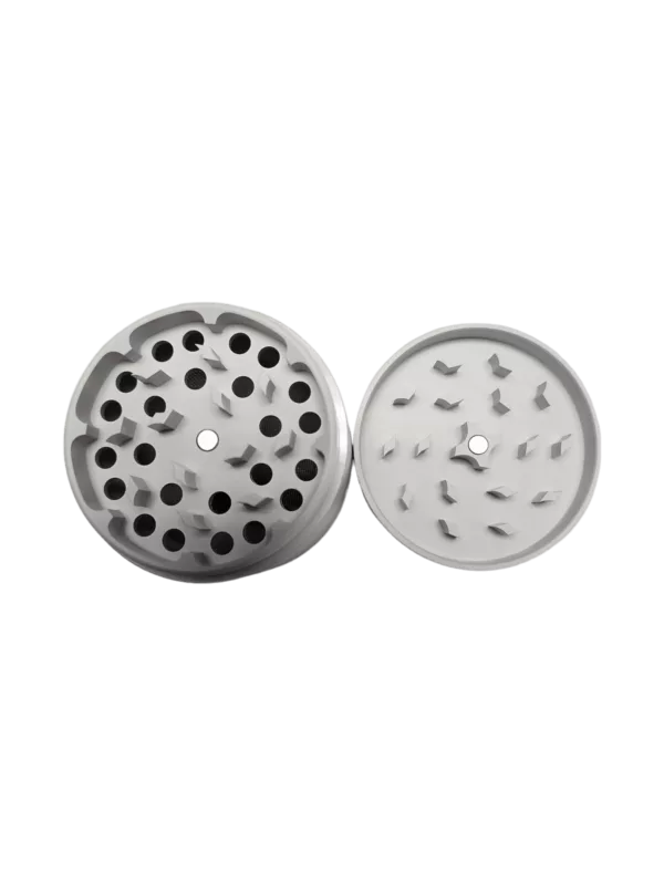 Metal grinder with circular shape and small hole in center. Used for grinding nuts, seeds, herbs, spices, and medications. Made of durable stainless steel, easy to clean and maintain. Compact and easy to use.