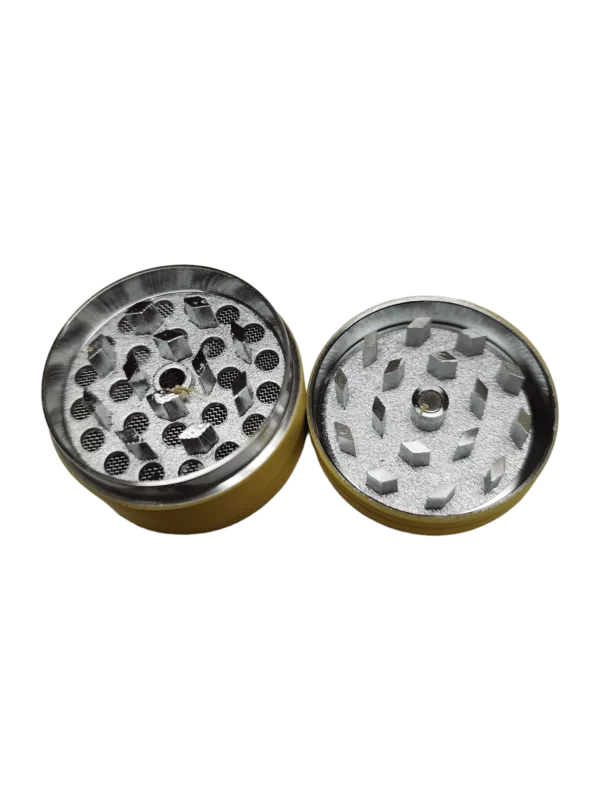 A brass grinder with a circular shape and small hole in the center, designed for grinding herbs and spices into small pieces for cooking and other culinary applications. It is made of durable materials, easy to use and clean, compact and versatile.