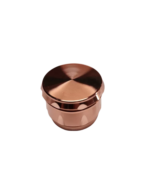 Copper-colored 3-chamber grinder with smooth, cylindrical shape and open side. Large middle chamber, smaller chambers on either side. Functional and simple design.