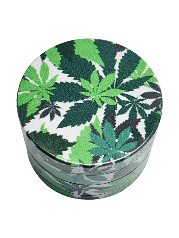 Round grinder with green & black leaf print, white background, & small green leaves. Small circular opening on top.