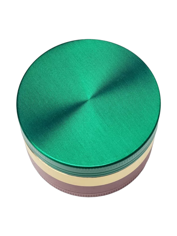 Rasta Shine 4 Part Grinder - BVGS06752 features a round metal container with a green and pink color scheme and a smooth surface, likely used as a decorative item.
