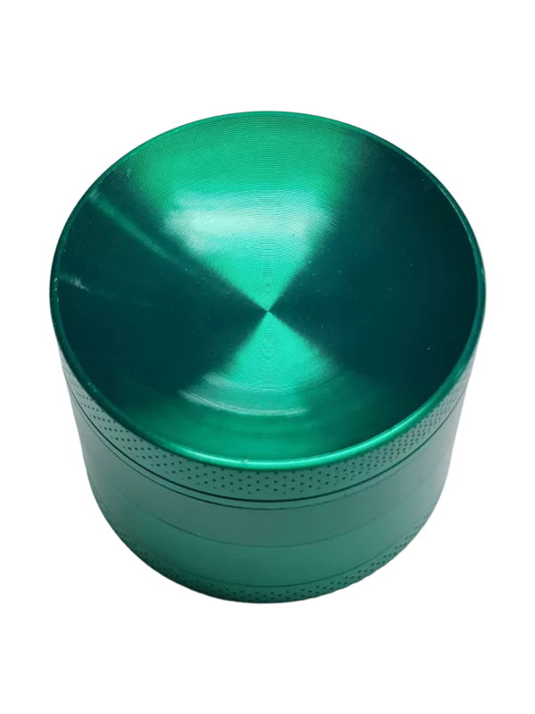 A circular green plastic grinder with two circular holes on top for herb material.