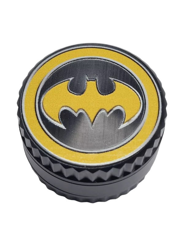 Batman-themed grinder with yellow and black logo, large handle and small knobs. Sleek and modern design.