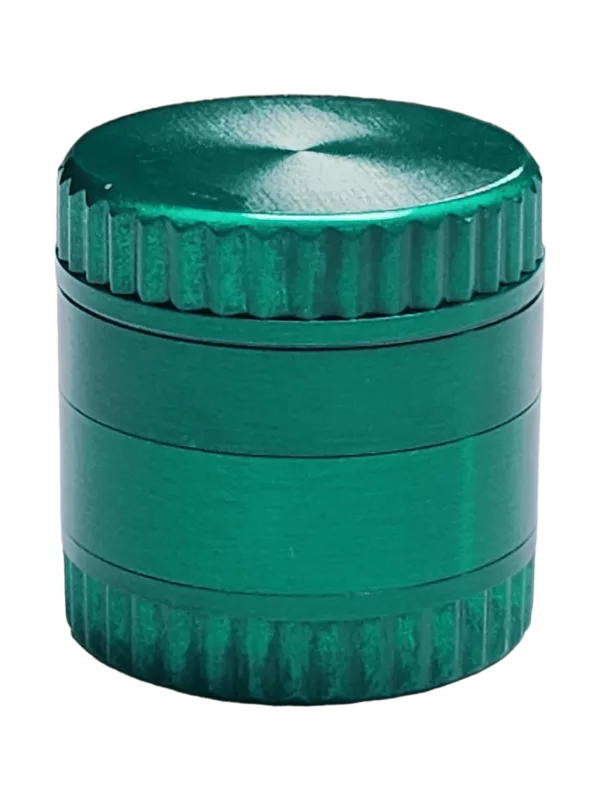 Green metal container with a rectangular shape and a lid with a small hole, suitable for storing and grinding herbs.