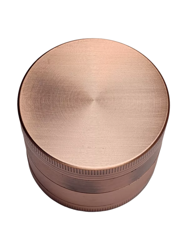 Copper metal grinder with smooth surface and small center hole, available on smoking company website.