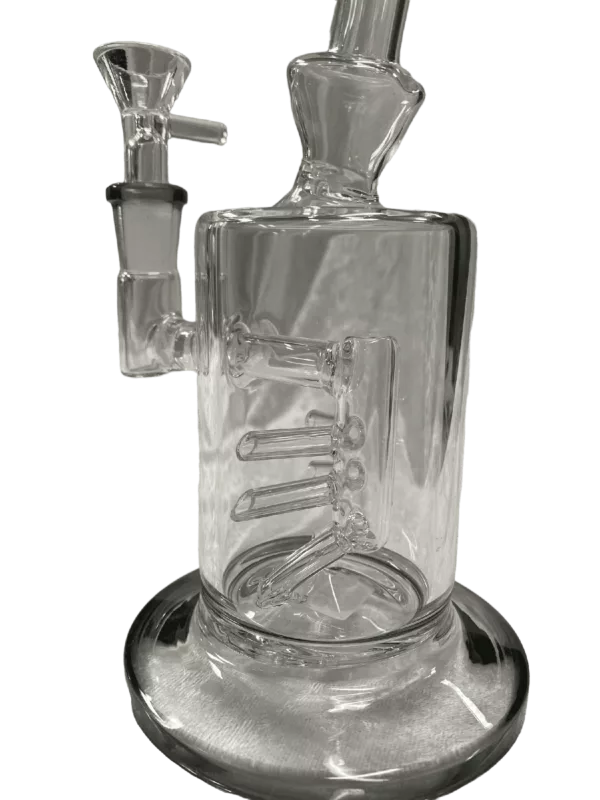 A clear, cylindrical glass bong with a small, flared bowl and a perforated disc cover. It sits on a flat, metal stand with two circular feet. The bong is symmetrical and has a transparent body.