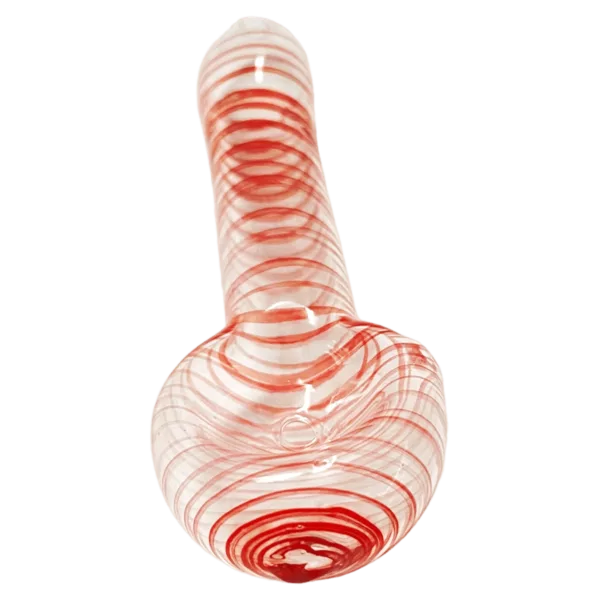 Red and white striped glass spoon with curved handle, standing upright on a table with a light background.
