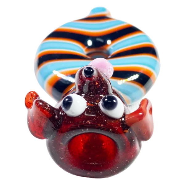A small glass doughnut with a face and eyes, representing a belly button, by Jem Glass.