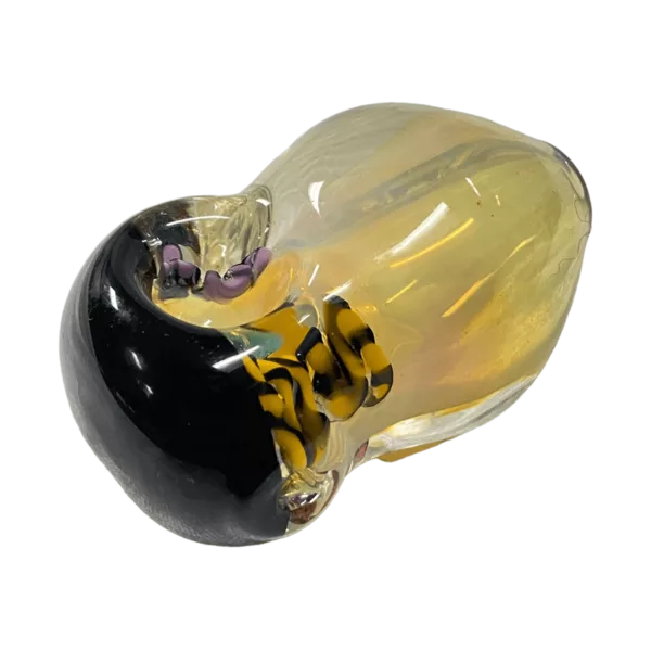 Small round glass bead with yellow and black interlocking circle design. Smooth, glossy surface. Clear glass. Decorative item, possibly used as pendant or jewelry.