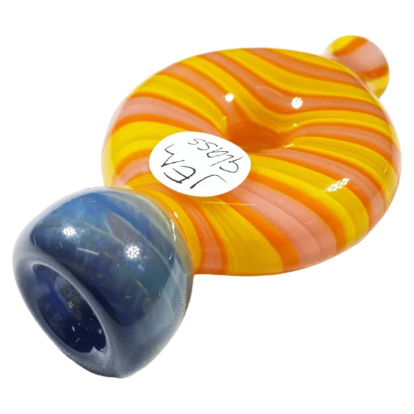 Blue and orange striped glass pipe with small and large holes, sitting on a green surface.