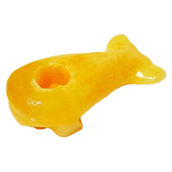 Small, orange fish-shaped object made of plastic or rubber. Mystic Stone Whale. Floating on water.