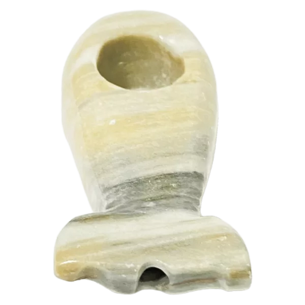 A small, white ceramic object with a curved shape and small hole on one end, sitting on a green background.