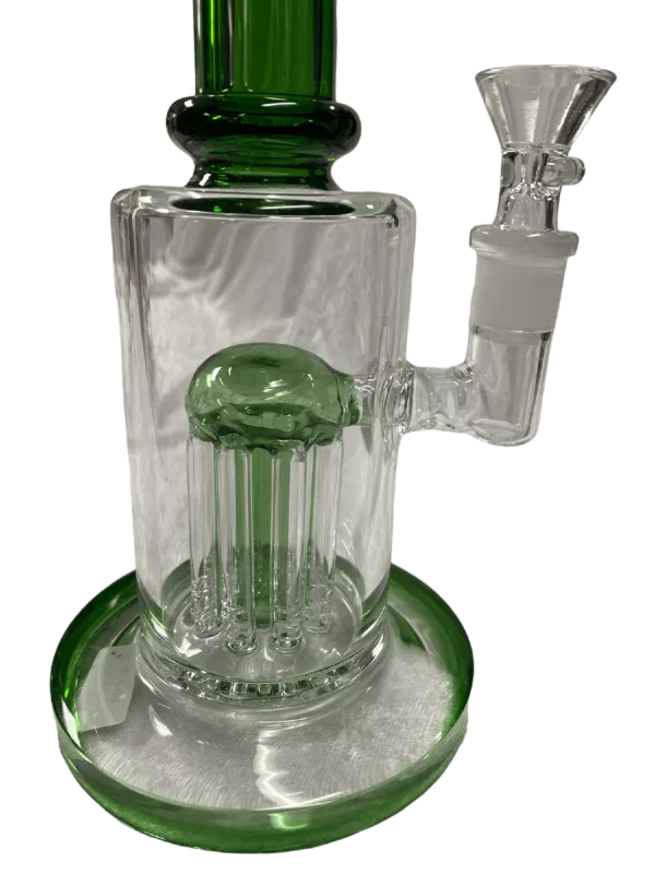 Clear glass bong with green base and shower perc. Small bowl and large stem, sitting on a clear plate and green surface.